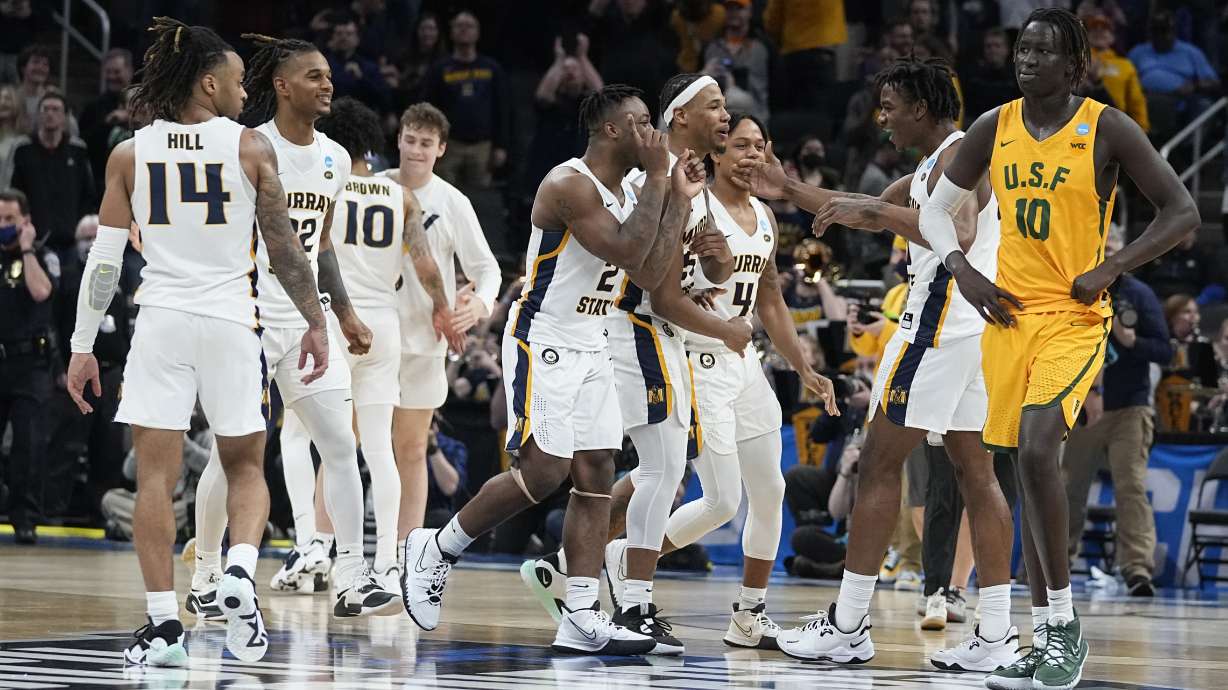 Murray State players celebrate as San Francisco forward Josh Kunen (10) walks off the court at the end of a college basketball game in the first round of the NCAA tournament, Friday, March 18, 2022, in Indianapolis. Murray State won 92-87 in overtime.