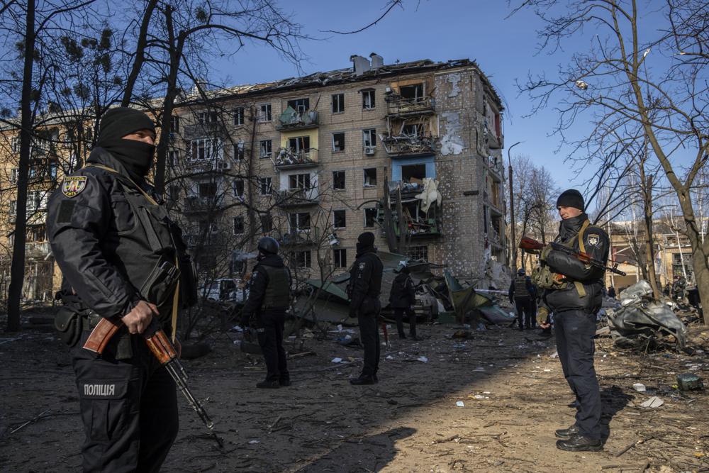 Policemen stand guard at the site where a bombing damaged residential buildings in Kyiv, Ukraine, Friday. Russian forces pressed their assault on Ukrainian cities Friday, with new missile strikes and shelling on the edges of the capital Kyiv.