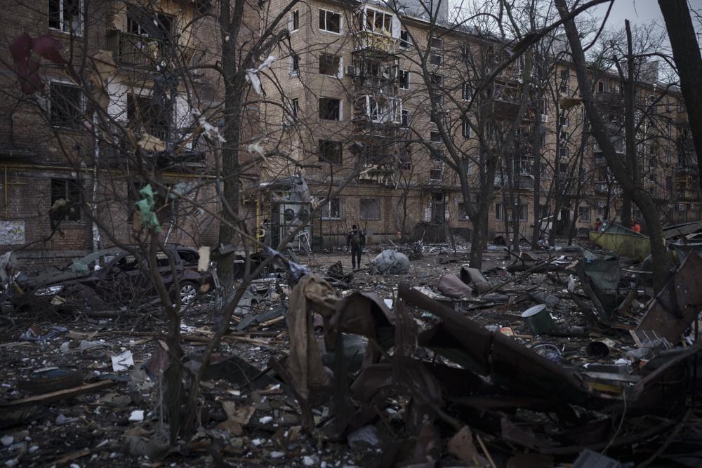 A police officer walks at the site of a bombing that damaged residential buildings in Kyiv, Ukraine, Friday. Russian forces pressed their assault on Ukrainian cities Friday, with new missile strikes and shelling on the edges of Kyiv and Lviv.