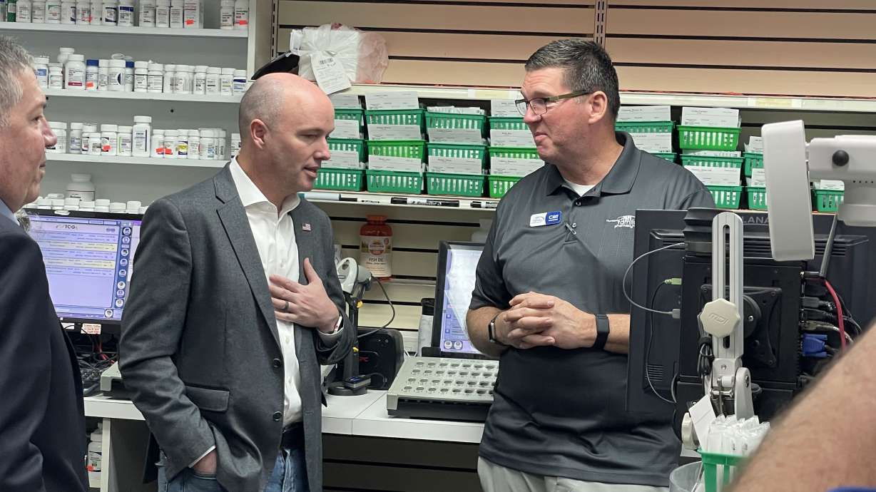 Gov. Spencer Cox thanks Cliff Holt, owner of Hurricane Family Pharmacy, for his business's service to its community during the pandemic on Friday.