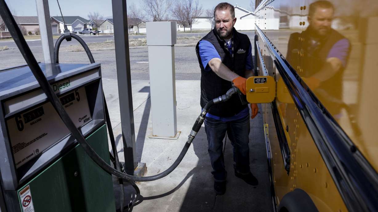 Shaun Adams, assistant director of transportation for Tooele County School District, pumps gas into a school bus at a state fuel center in Tooele on Friday.
