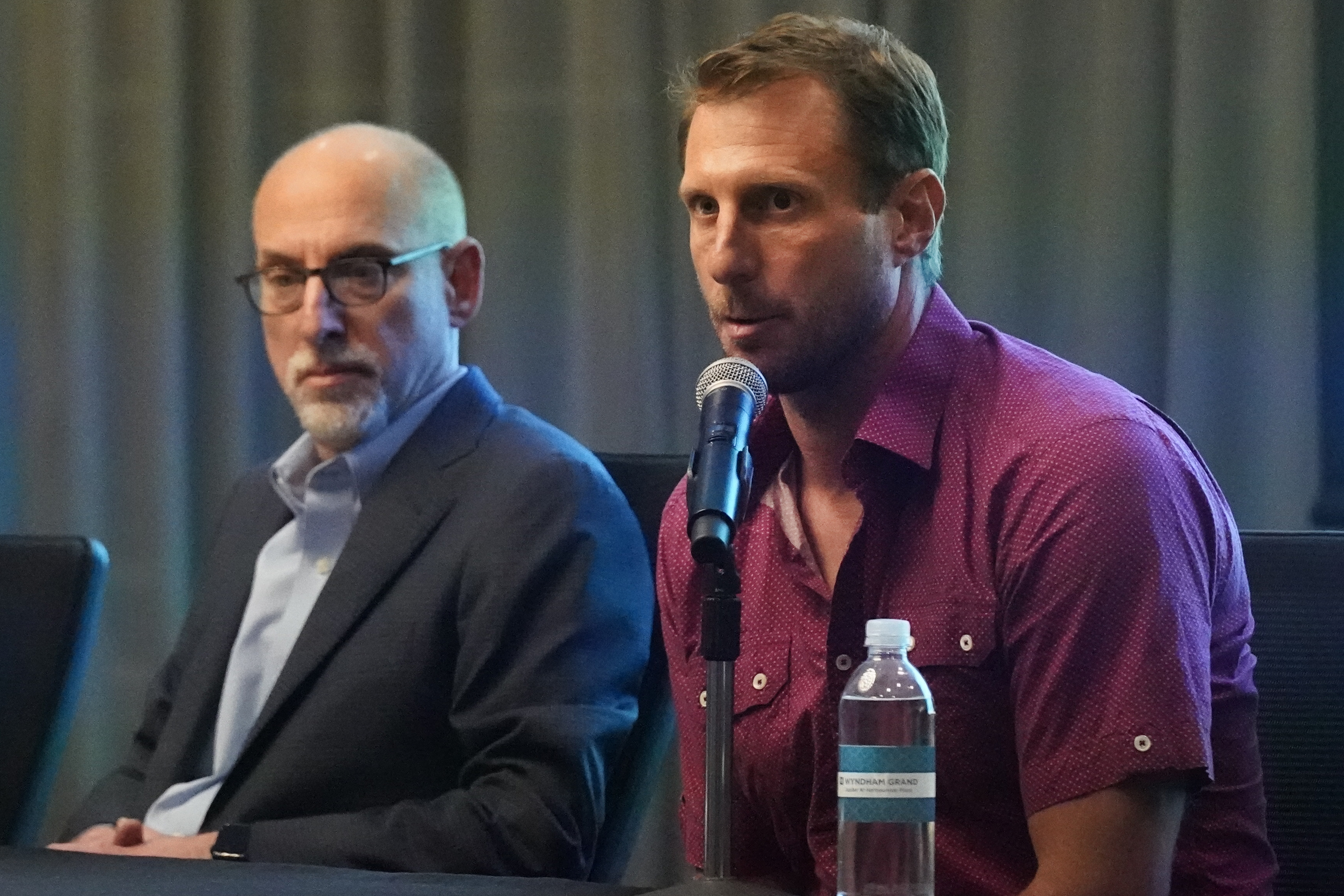 New York Mets pitcher Max Scherzer, right, speaks as Bruce Meyer, chief union negotiator, listens during a news conference Tuesday, March 1, 2022, in Jupiter, Fla. Major League Baseball has canceled opening day. Commissioner Rob Manfred announced Tuesday the sport will lose regular-season games over a labor dispute for the first time in 27 years after acrimonious lockout talks collapsed in the hours before management's deadline. 