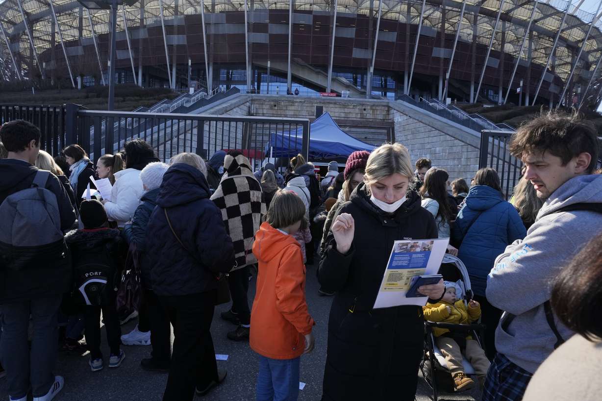 Hundreds of refugees from Ukraine wait in line to apply for Polish ID numbers that will entitle them to work, free health care and education at the National Stadium in Warsaw, Poland, on Saturday. The application points are not able to handle all those interested and ask many of them to come again.