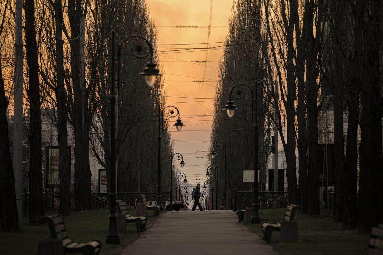A man walks at dusk in Kyiv, Ukraine, Saturday.