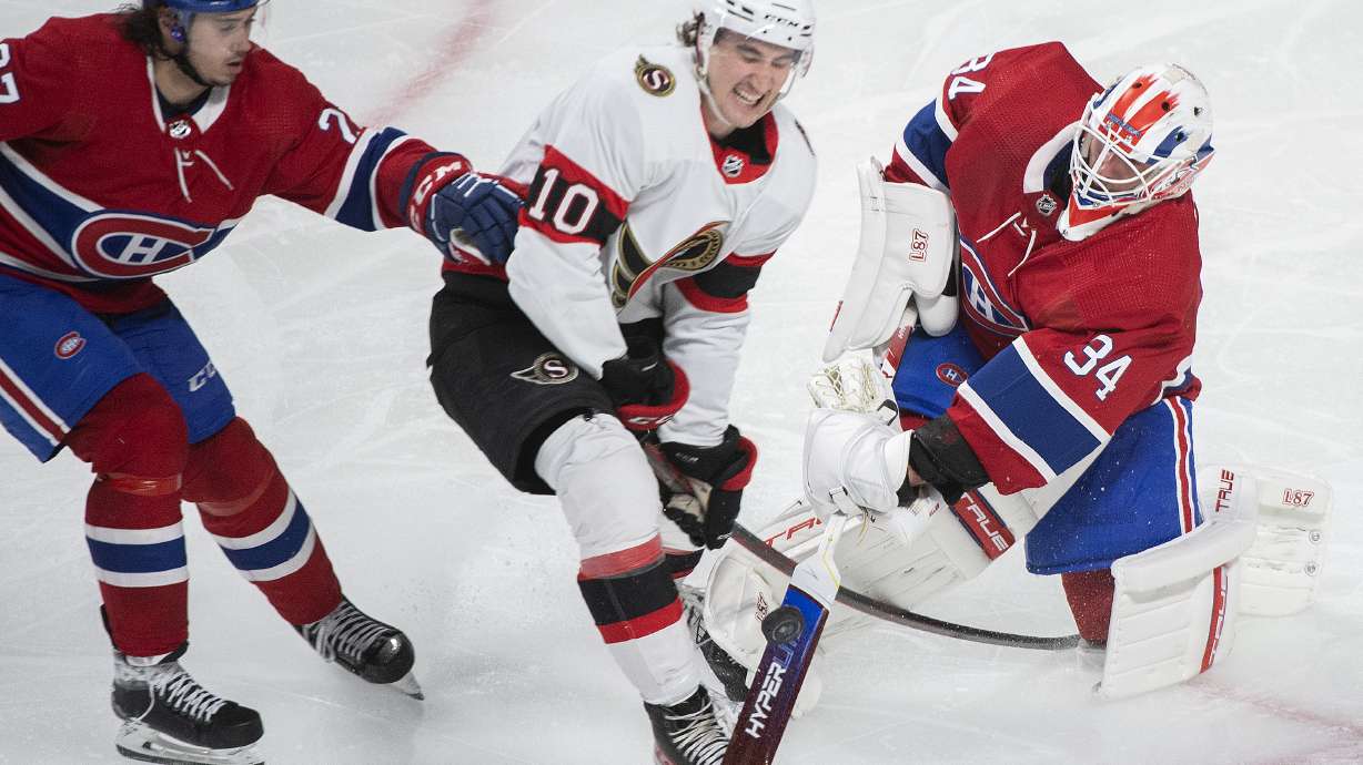 Montreal Canadiens goaltender Jake Allen clears the puck as Ottawa Senators' Alex Formenton (10) and Canadiens' Alexander Romanov (27) move in during the third period of an NHL hockey game Saturday, March 19, 2022, in Montreal.