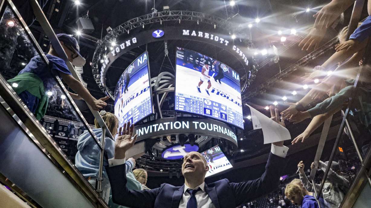 BYU coach Mark Pope high fives with fans after a win over Northern Iowa in a NIT game at the Marriott Center in Provo, March 19, 2022.