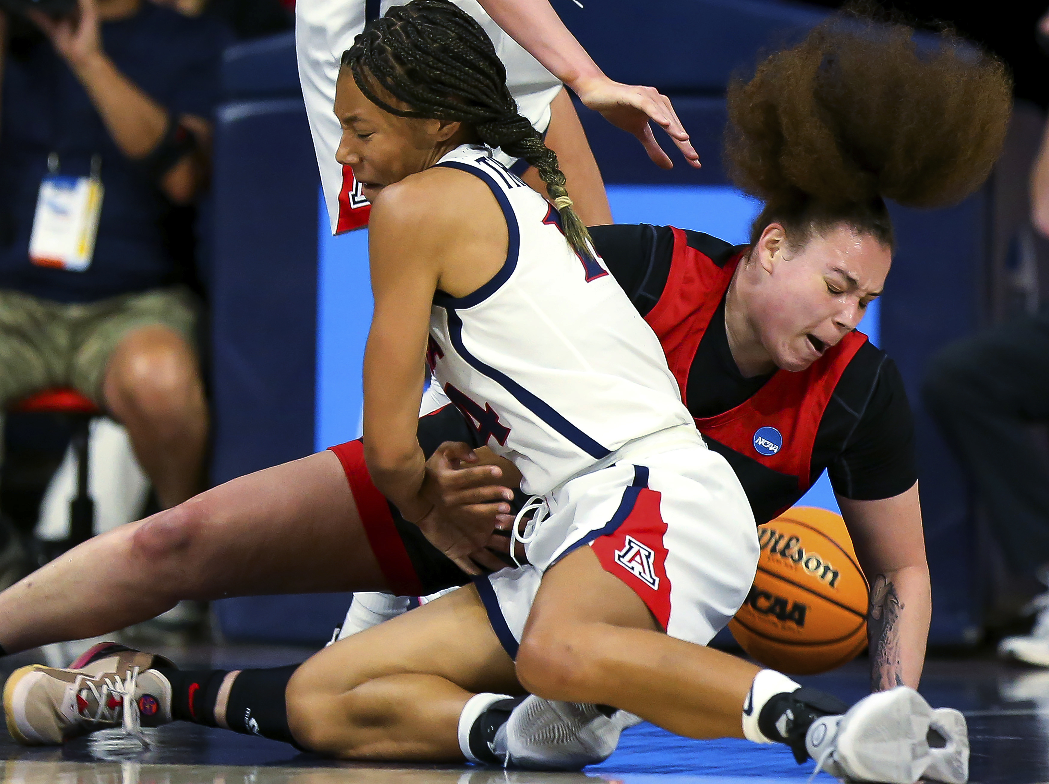 Arizona forward Sam Thomas (14) and UNLV forward Khayla Rooks (20) fall to the court after Thomas tried to steal the ball during a first-round game in the NCAA women's college basketball tournament Saturday, March 19, 2022, in Tucson, Ariz. 