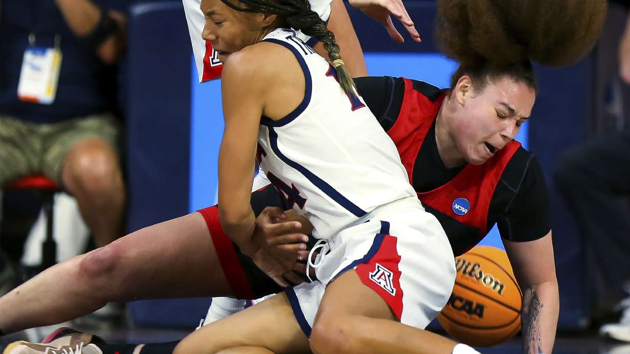 Arizona forward Sam Thomas (14) and UNLV forward Khayla Rooks (20) fall to the court after Thomas tried to steal the ball during a first-round game in the NCAA women's college basketball tournament Saturday, March 19, 2022, in Tucson, Ariz.