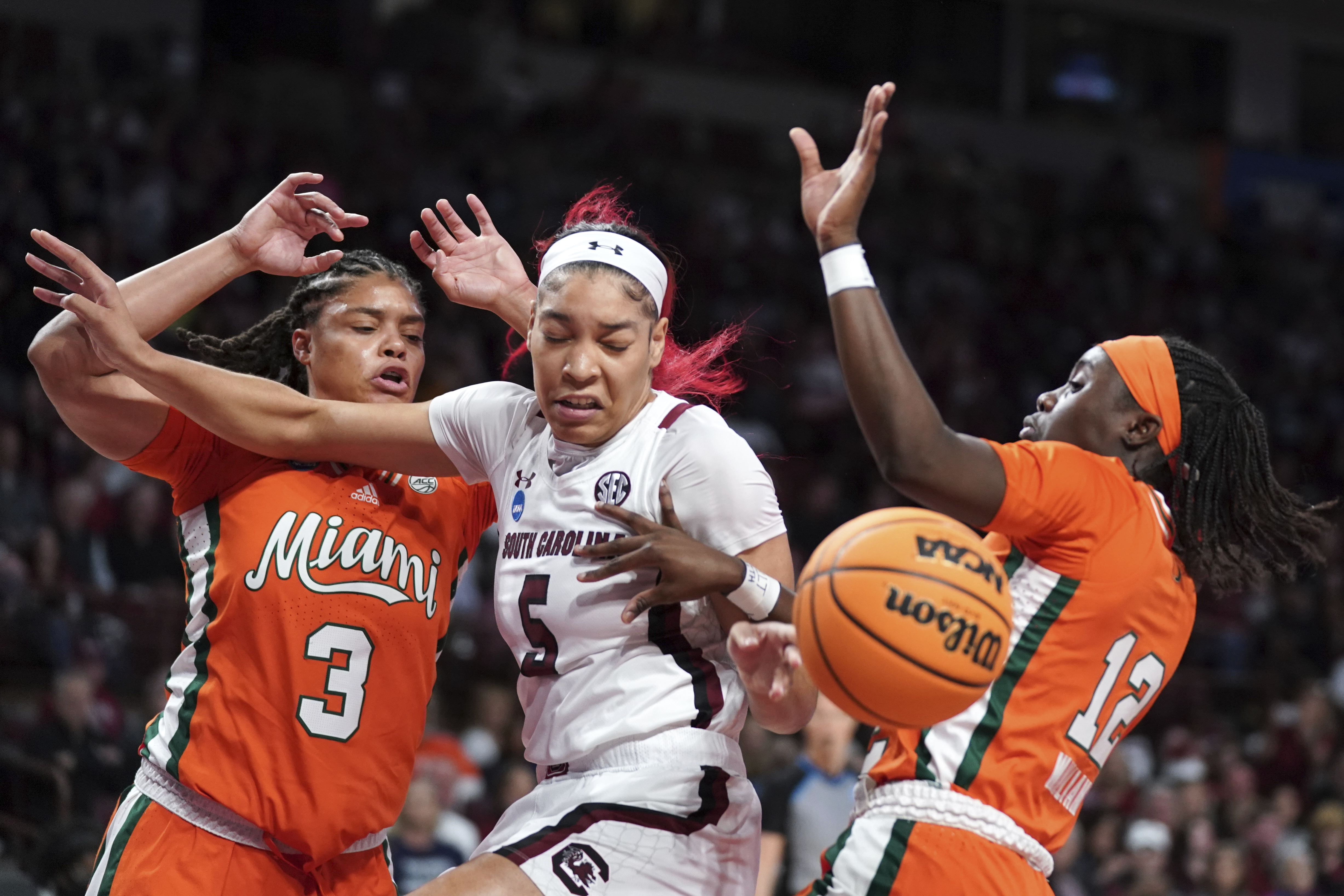 South Carolina forward Victaria Saxton (5) battles for the ball against Miami forward Destiny Harden (3) and guard Ja'Leah Williams (12) during the first half a second-round game in the NCAA college basketball tournament Sunday, March 20, 2022 in Columbia, S.C. 