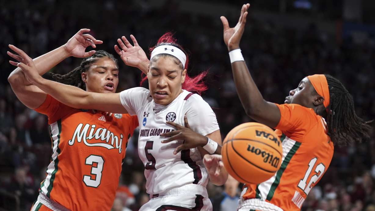 South Carolina forward Victaria Saxton (5) battles for the ball against Miami forward Destiny Harden (3) and guard Ja'Leah Williams (12) during the first half a second-round game in the NCAA college basketball tournament Sunday, March 20, 2022 in Columbia, S.C.