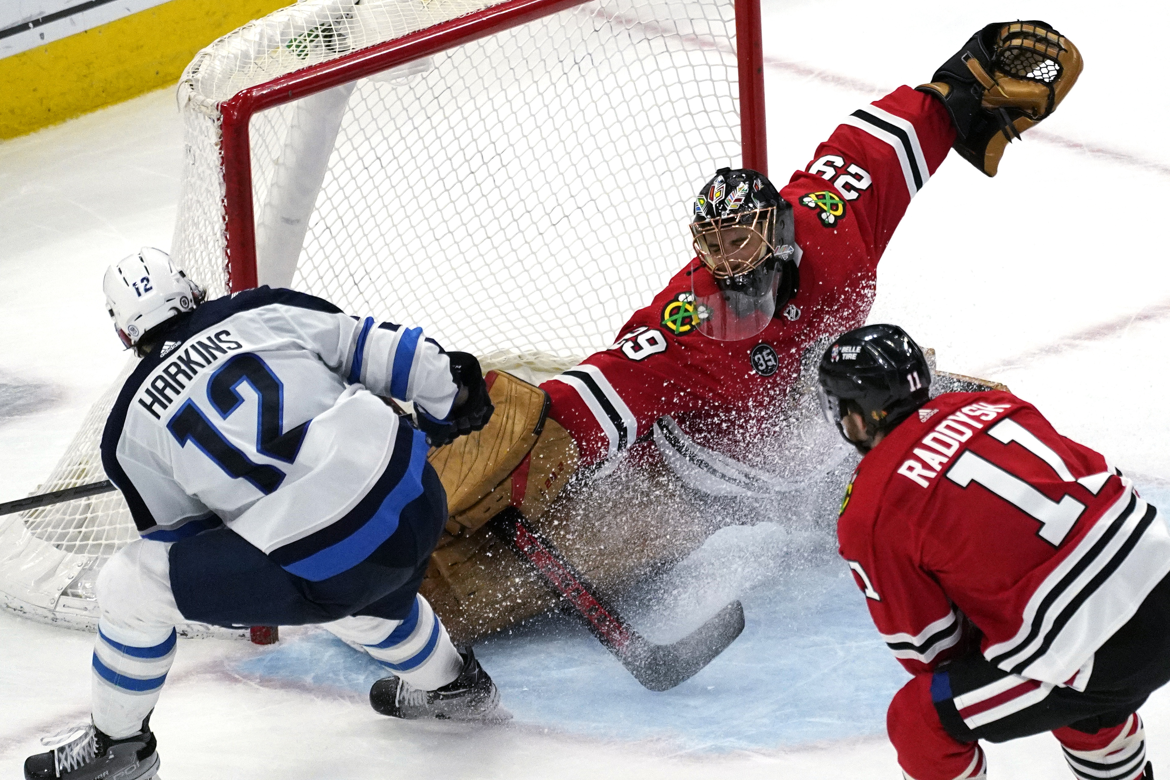 Chicago Blackhawks goaltender Marc-Andre Fleury (29) cannot make the save on a goal by Winnipeg Jets center Jansen Harkins (12) during the second period of an NHL hockey game in Chicago, Sunday, March 20, 2022. 