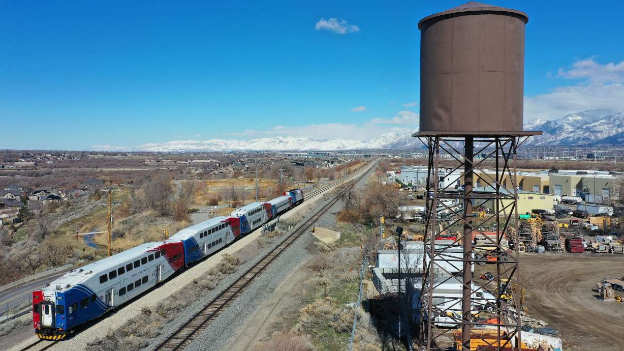 A Utah Transit Authority FrontRunner travels past a water tower in Bluffdale on March 10. With gas prices surging to record highs, some Utahns are trading in the convenience of driving a car for the cost savings of taking public transportation.