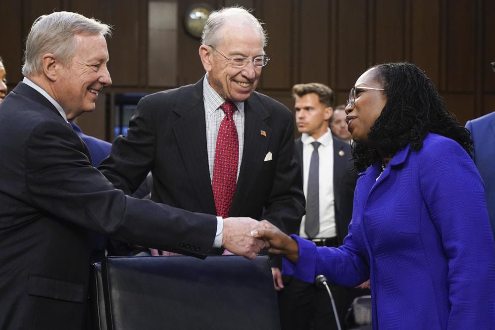 Supreme Court nominee Judge Ketanji Brown Jackson greets Sen. Dick Durbin, D-Ill., chairman of the Senate Judiciary Committee, as Sen. Chuck Grassley, R-Iowa, the ranking member of the Senate Judiciary Committee, watches, as she arrives for her confirmation hearing before the Senate Judiciary Committee Monday on Capitol Hill in Washington.