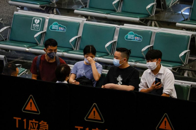 People sit in an area where relatives of the passengers of the China Eastern Airlines Boeing 737-800 plane, which crashed in Wuzhou flying from Kunming to Guangzhou, wait for news, at Guangzhou Baiyun International Airport in Guangzhou, Guangdong province, China Monday.