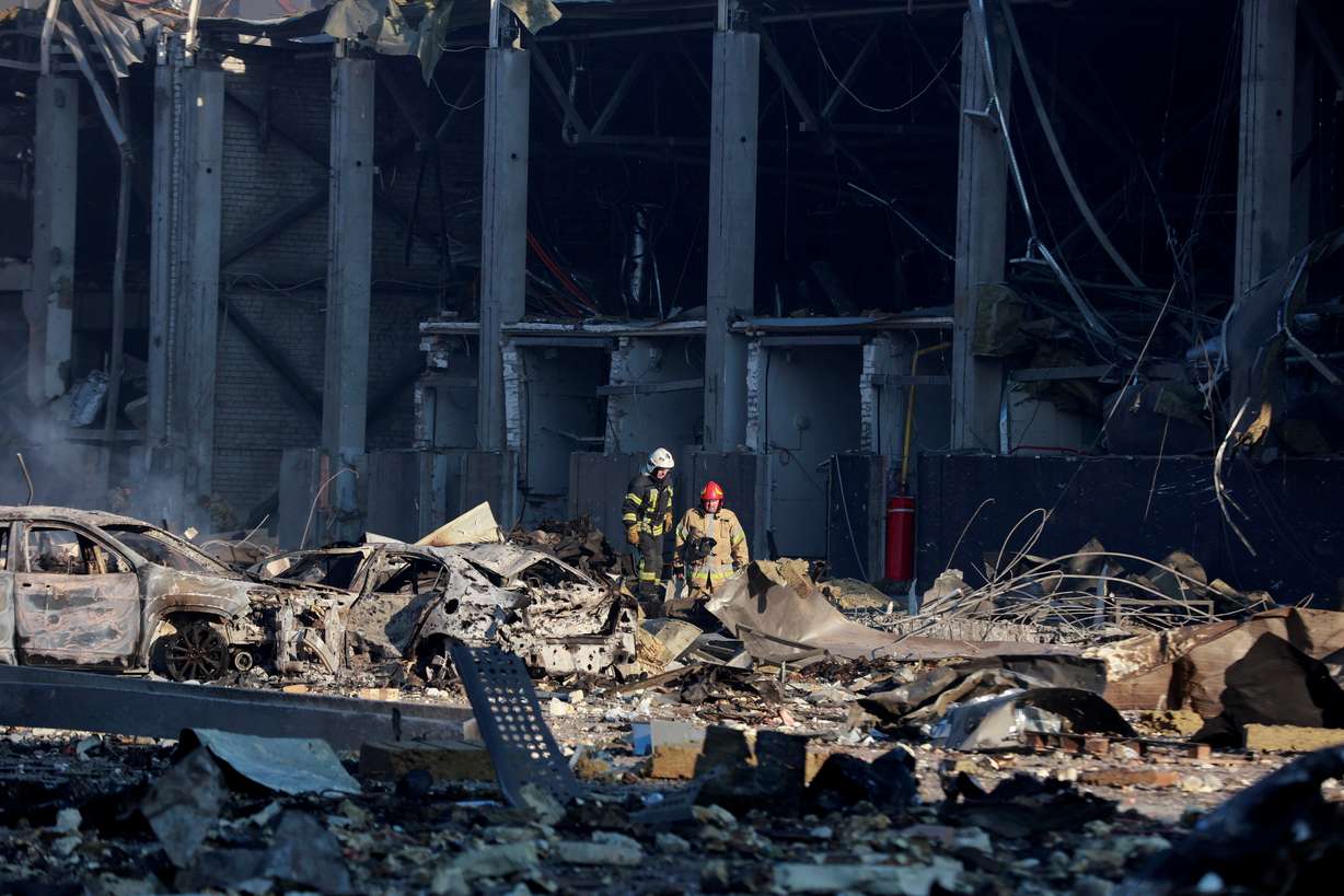 Rescue workers stand at the site of a military strike on a shopping center in the Podilskyi district of Kyiv, as Russia's invasion of Ukraine continues, in Kyiv, Ukraine March 21, 2022.