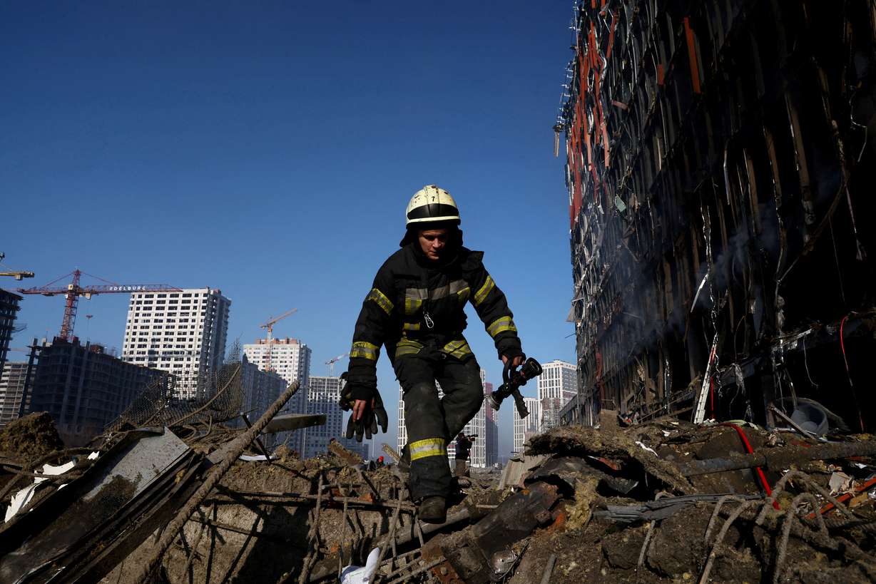 A rescuer walks through debris at the site of a bombing at a shopping center as Russia's invasion of Ukraine continues, in Kyiv, Ukraine March 21, 2022.