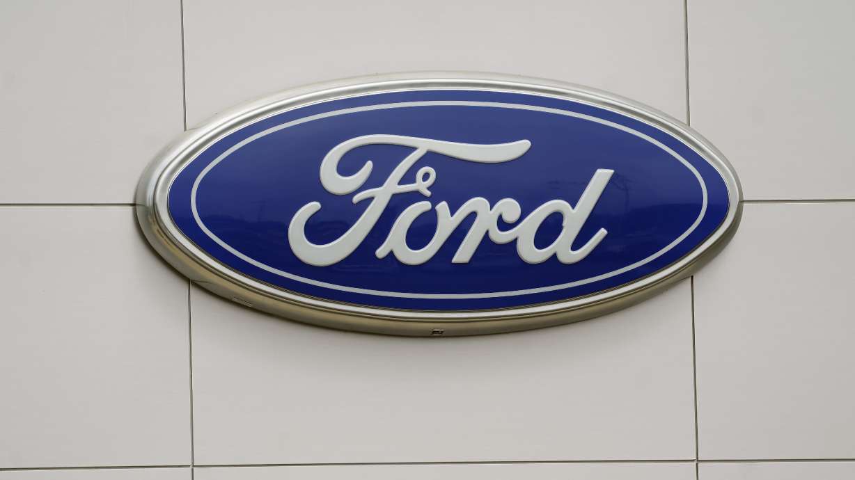 Ford is recalling nearly 215,000 pickup trucks and large SUVs in the U.S. and Canada Tuesday because brake fluid can leak and cause longer stopping distances.