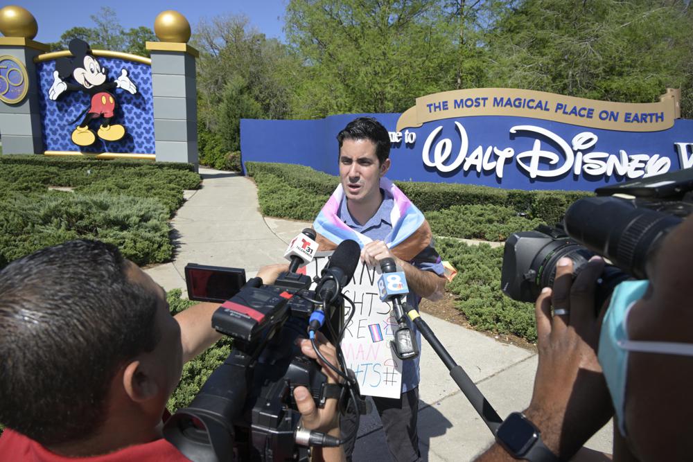Disney cast member Nicholas Maldonado talks to reporters while protesting his company's stance on LGBTQ issues and participating in an employee walkout at Walt Disney World, Tuesday, in Lake Buena Vista, Fla.
