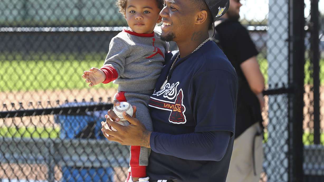 Atlanta Braves outfielder Ronald Acuna smiles with his son Ronald Acuna Jr. at baseball spring training in North Port, Fla., Thursday, March 17, 2022.