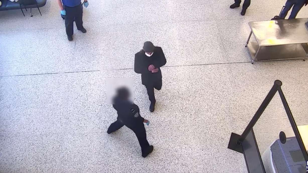 Surveillance video shows a man about to walk past a police officer into a secure area at the Salt Lake City International Airport. He was later taken into custody after he physically fought with another officer.