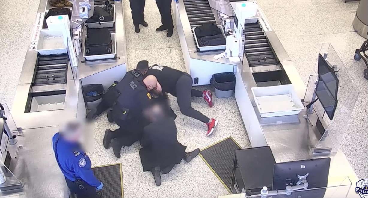 Surveillance video shows a man being wrestled to the ground by police officers and a bystander after he breached a secure area at the Salt Lake City International Airport. He was eventually taken into custody.