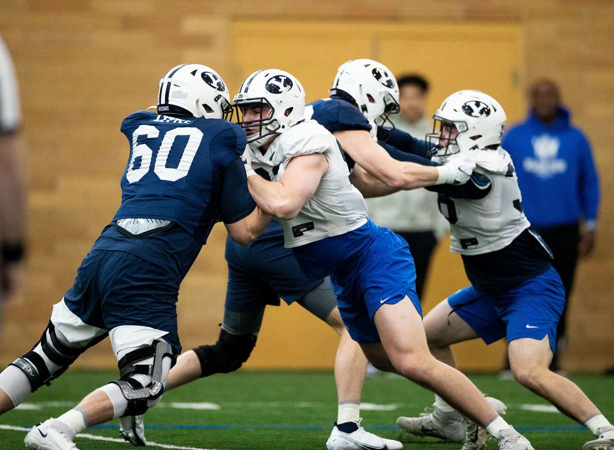 BYU offensive and defensive linemen run drills during spring football practice, March 7, 2022 inside the Indoor Practice Facility in Provo.
