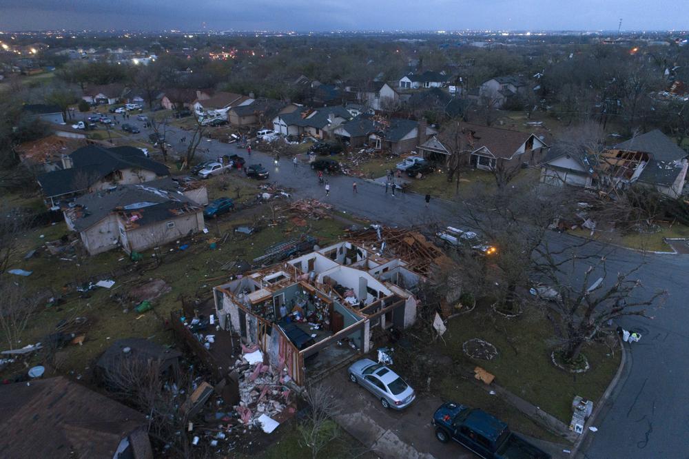 Debris litters the ground surrounding homes, damaged by a tornado, on Oxford Drive and Stratford Drive in Round Rock, Texas on Monday.