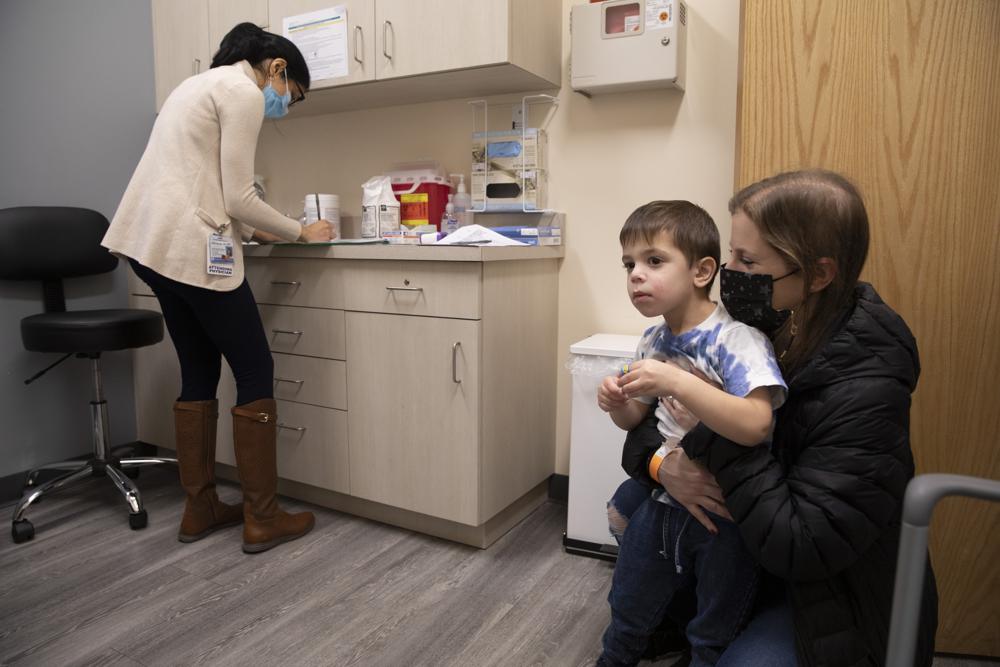 Ilana Diener holds her son, Hudson, 3, during an appointment for a Moderna COVID-19 vaccine trial in Commack, N.Y. on Nov. 30, 2021. On Wednesday Moderna said its COVID-19 vaccine works in babies, toddlers and preschoolers, and if regulators agree it could mean a chance to finally start vaccinating the littlest kids by summer.
