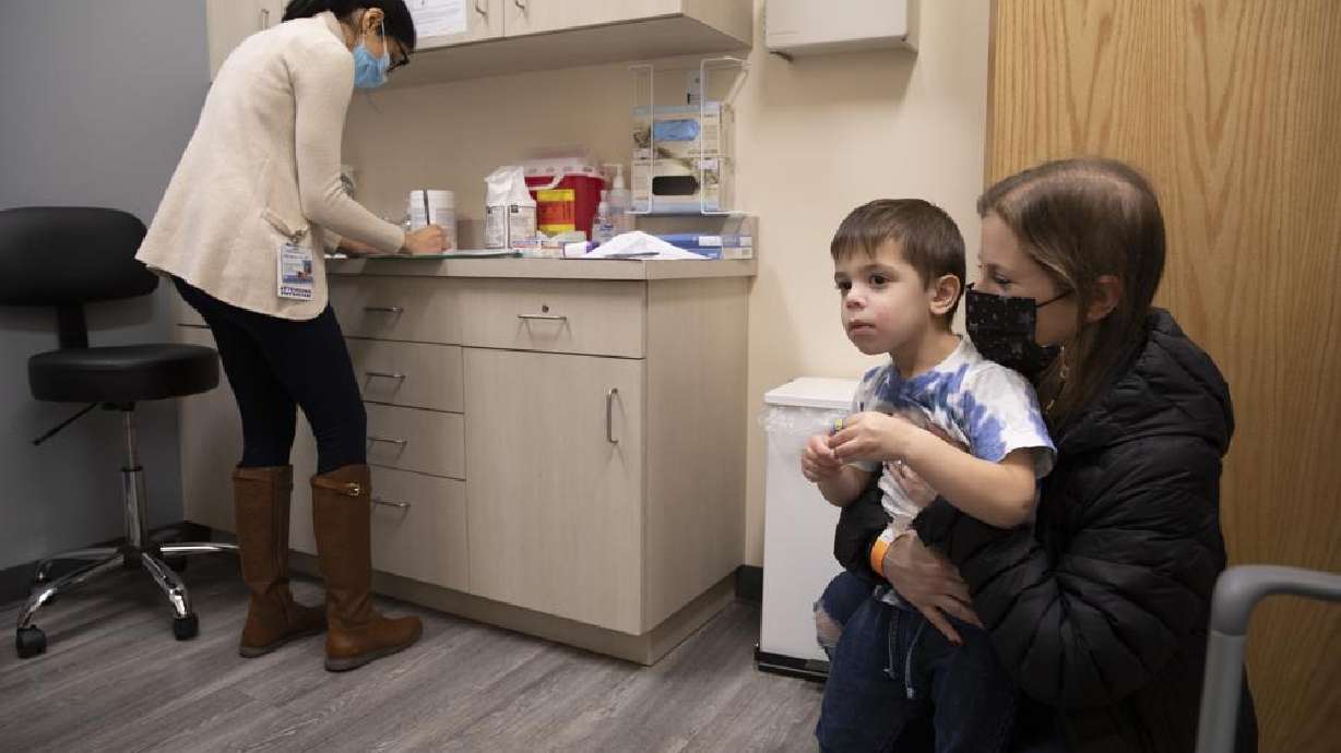 Ilana Diener holds her son, Hudson, 3, during an appointment for a Moderna COVID-19 vaccine trial in Commack, N.Y. on Nov. 30, 2021. On Wednesday Moderna said its COVID-19 vaccine works in babies, toddlers and preschoolers, and if regulators agree it could mean a chance to finally start vaccinating the littlest kids by summer.