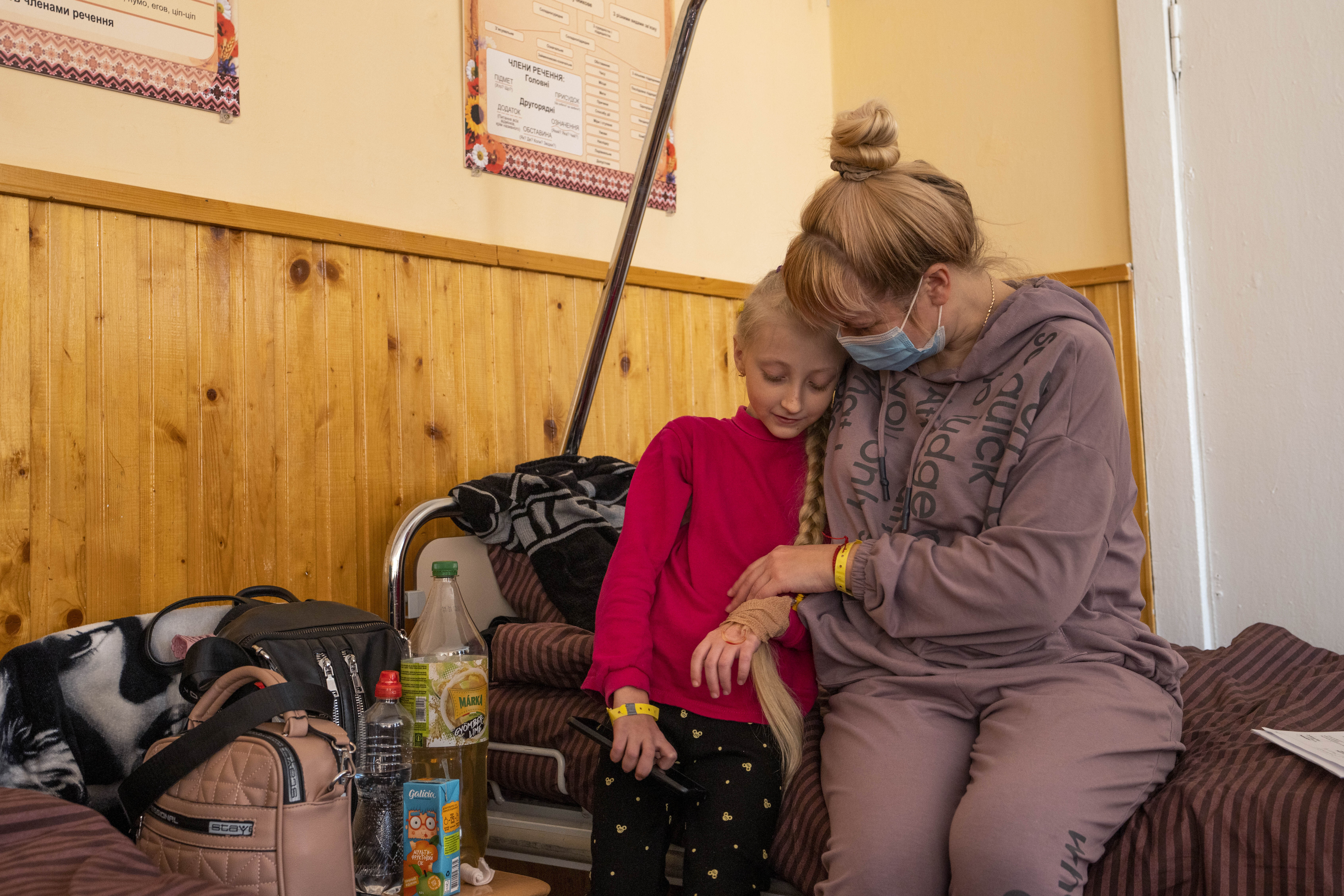Natalia Moiseinko holds her 10-year-old daughter Zlata Moiseinko, suffering from a chronic heart condition, as she receives treatment at a schoolhouse that has been converted into a field hospital in Mostyska, western Ukraine, Thursday.