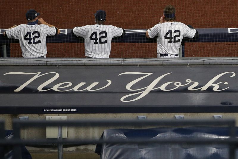 FILE PHOTO: Aug 28, 2020; Bronx, New York, USA; Members of the New York Yankees watch from the dugout during the third inning of the second game of a double header against the New York Mets at Yankee Stadium.