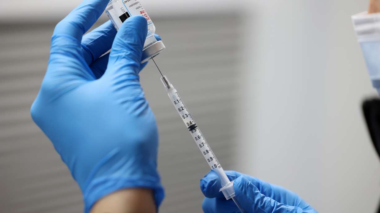 Christine Spencer fills a syringe with the Moderna COVID-19 vaccine in Salt Lake City on Dec. 29, 2021. Utah health officials on Thursday reported 699 new COVID-19 cases in the past seven days, as well as 16 additional deaths.