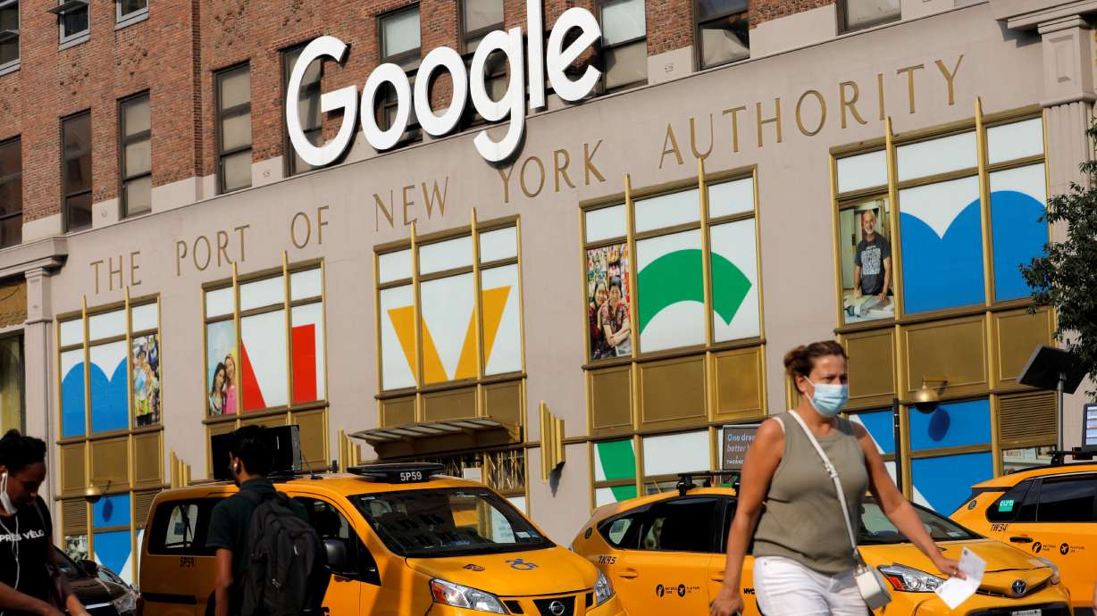 A person in a mask walks by the New York Google offices in New York City, July 29, 2021. Google announced on Thursday its latest plans for using smartphones to monitor health, saying it would test whether capturing heart sounds and eyeball images could help people identify issues from home.