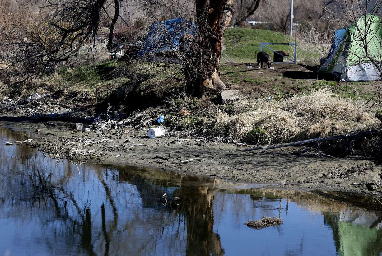Garbage is visible on the bank of the Jordan River at a homeless encampment in Salt Lake City on Wednesday.