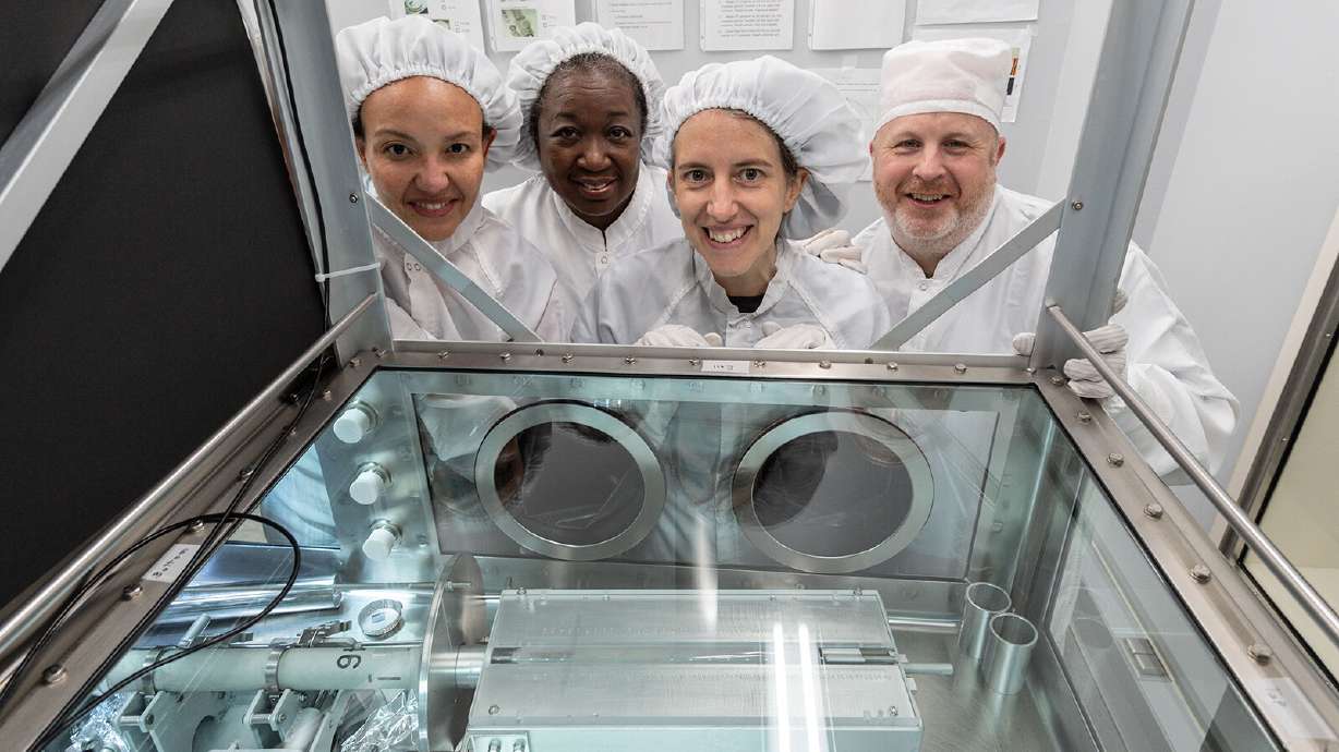 The processing team, including (from left) Charis Krysher, Andrea Mosie, Juliane Gross and Ryan Zeigler at NASA's Johnson Space Center, poses in front of the newly opened sample.
