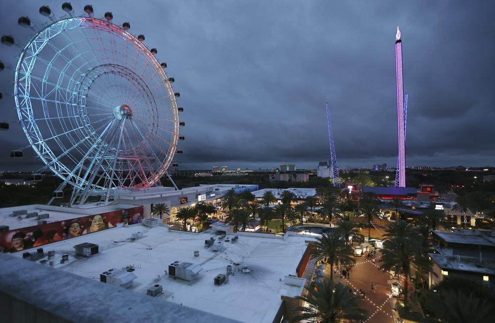 ICON Park attractions, The Wheel, left, Orlando SlingShot, middle, and Orlando FreeFall, right, are shown in Orlando, Fla., on Thursday. A 14-year-old boy fell to his death from a ride at an amusement park in Orlando, sheriff's officials said.