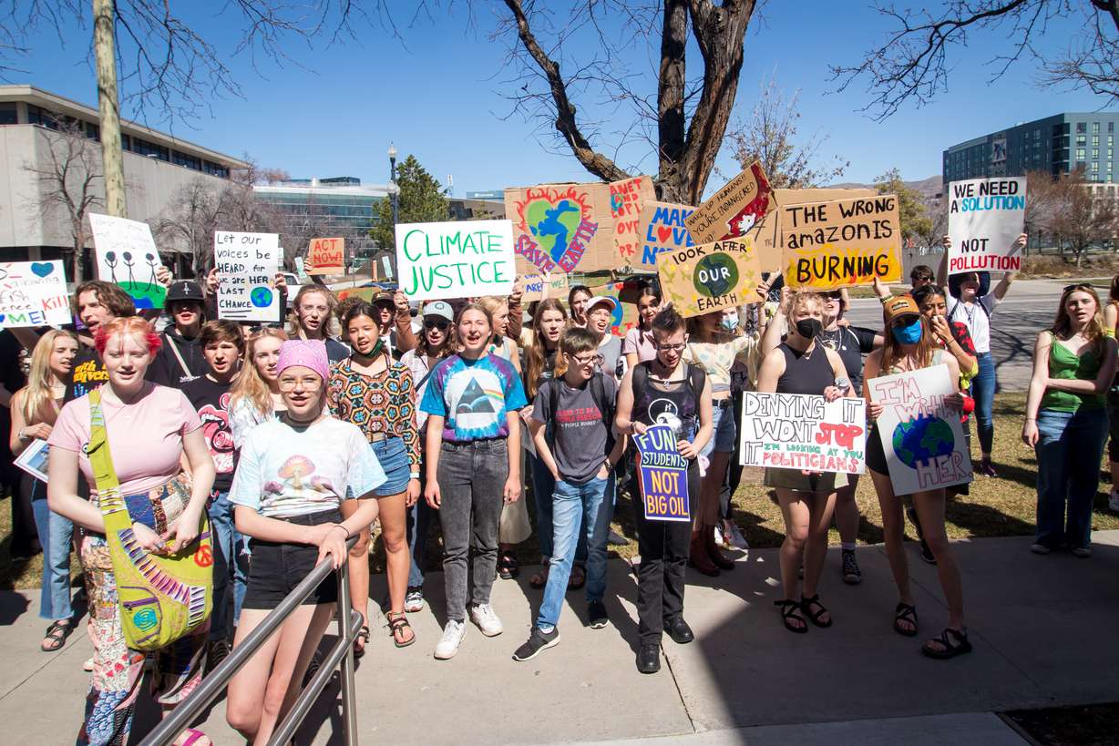 A group of a few dozen students chant and sing outside of the Utah State Board of Education building in Salt Lake City Friday.