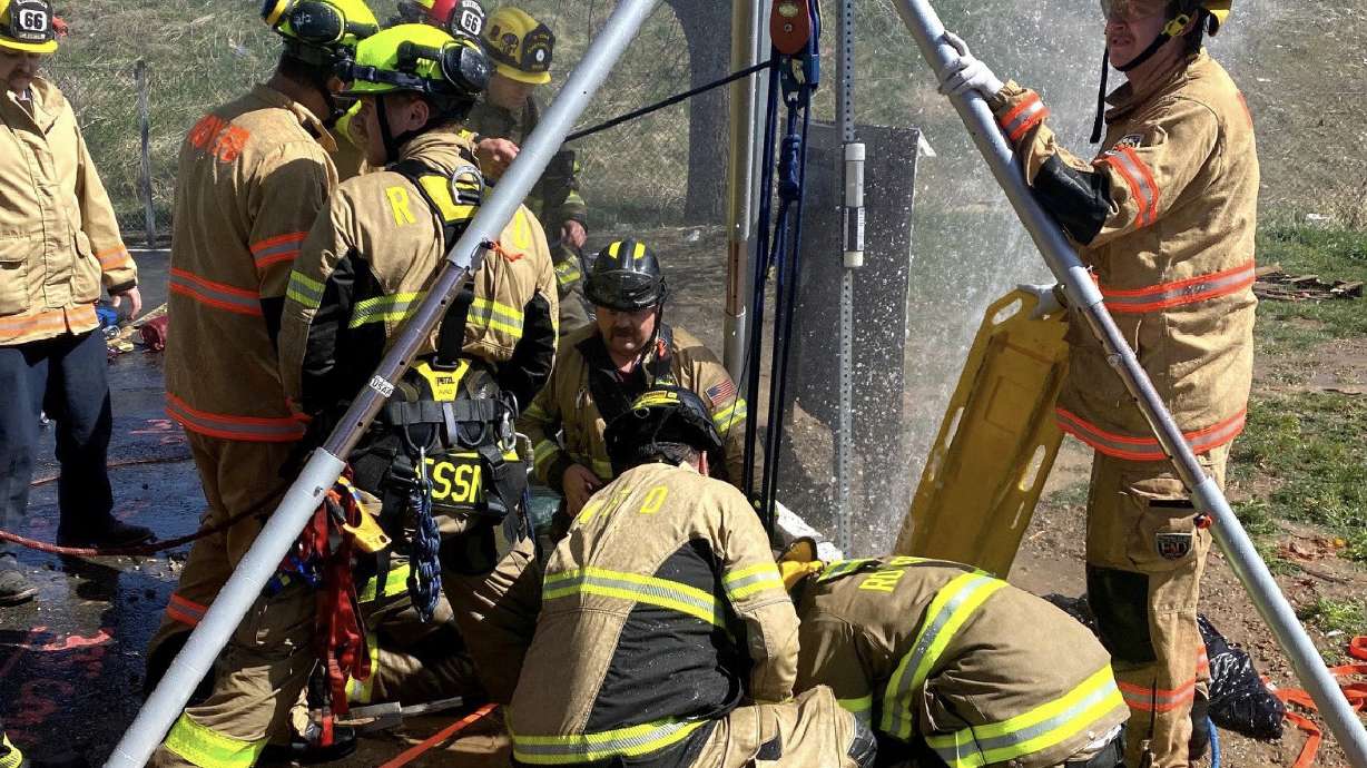 Fire crews work to rescue a woman who fell into a manhole and became trapped Friday afternoon near 1900 West and 6000 South in Roy. She was eventually freed and transported to a hospital with minor injuries.