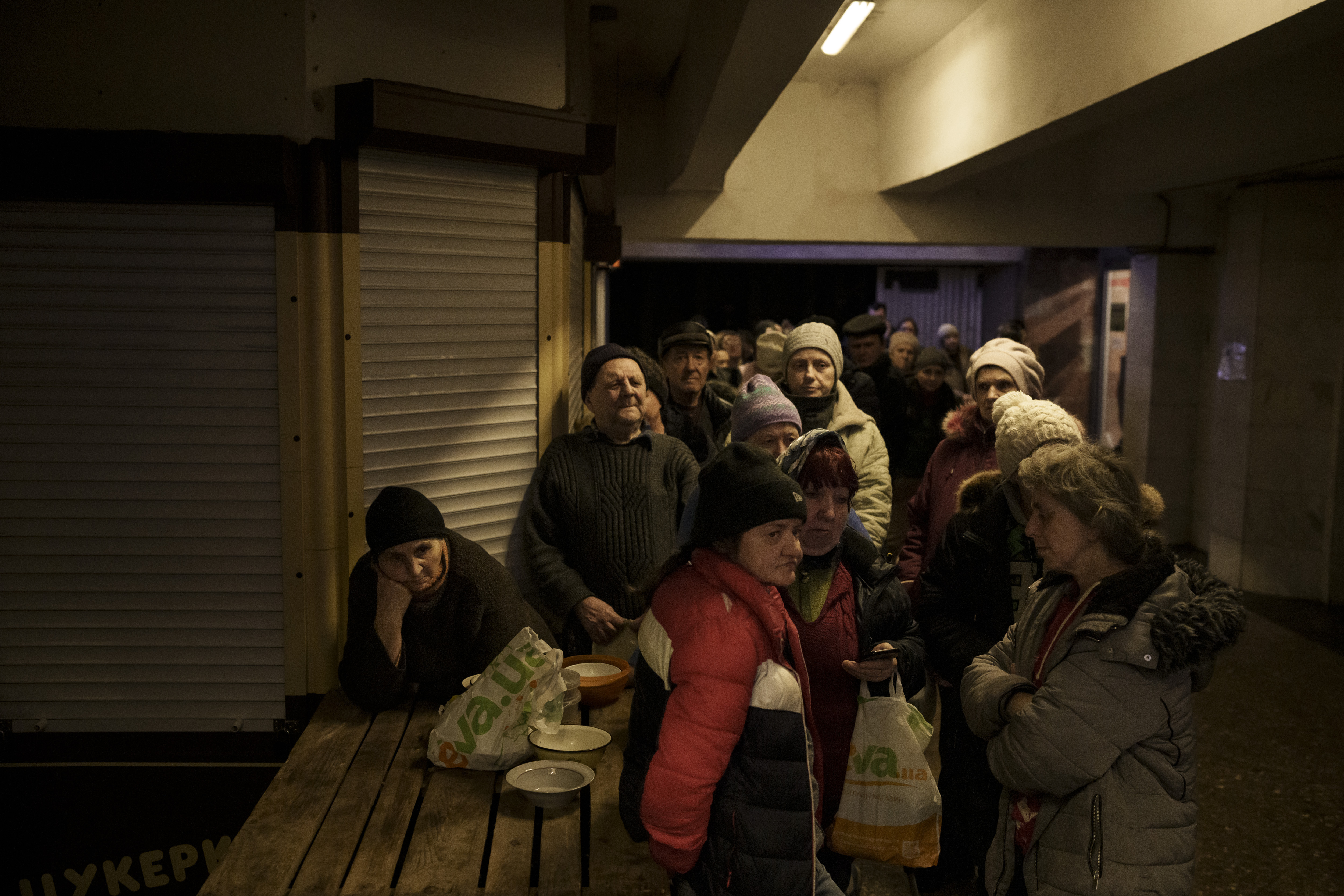 People line up for food in a subway station being used as a bomb shelter, as Russian attacks continue in Kharkiv, Ukraine, Friday.