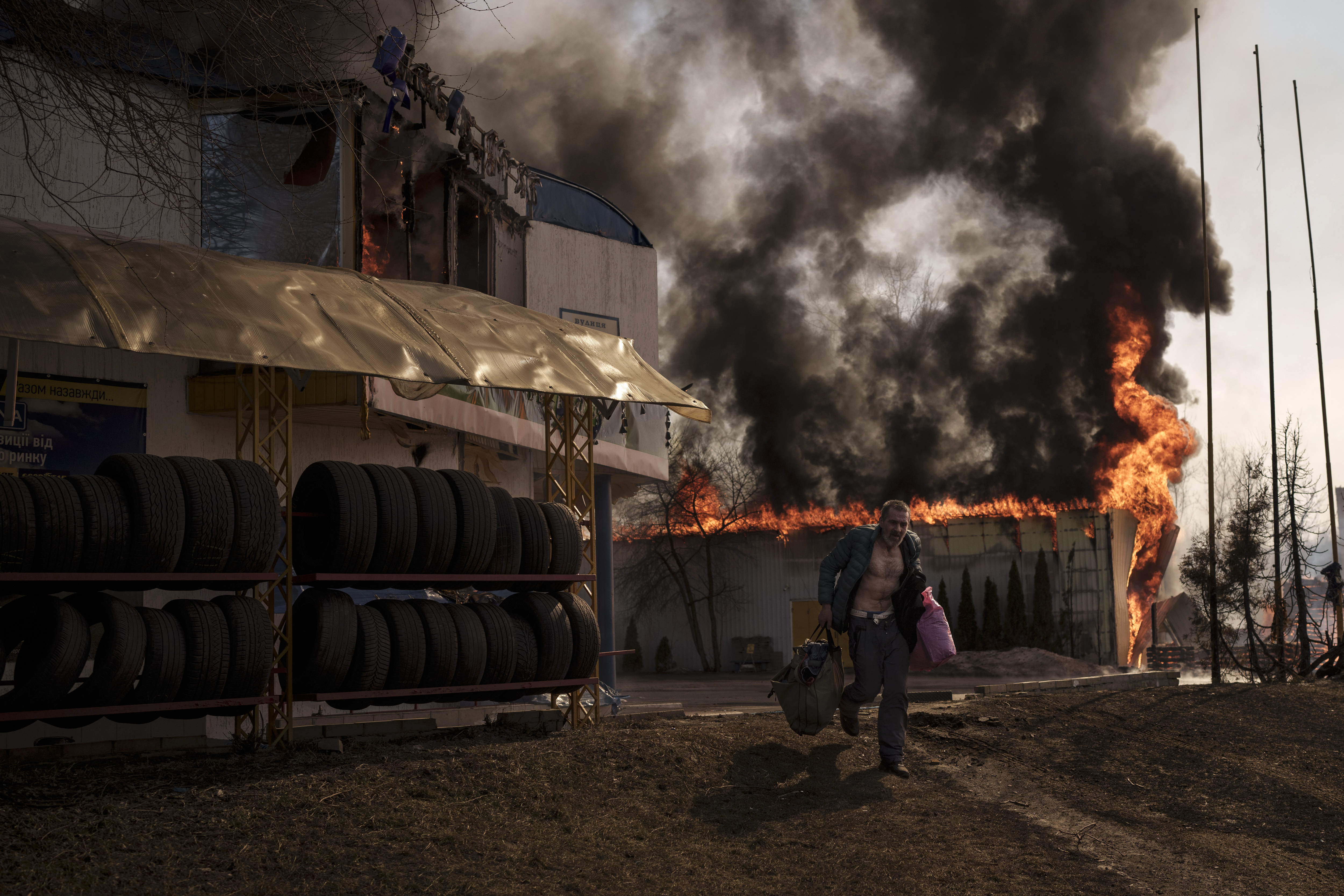 A man recovers items from a burning shop following a Russian attack in Kharkiv, Ukraine, Friday.