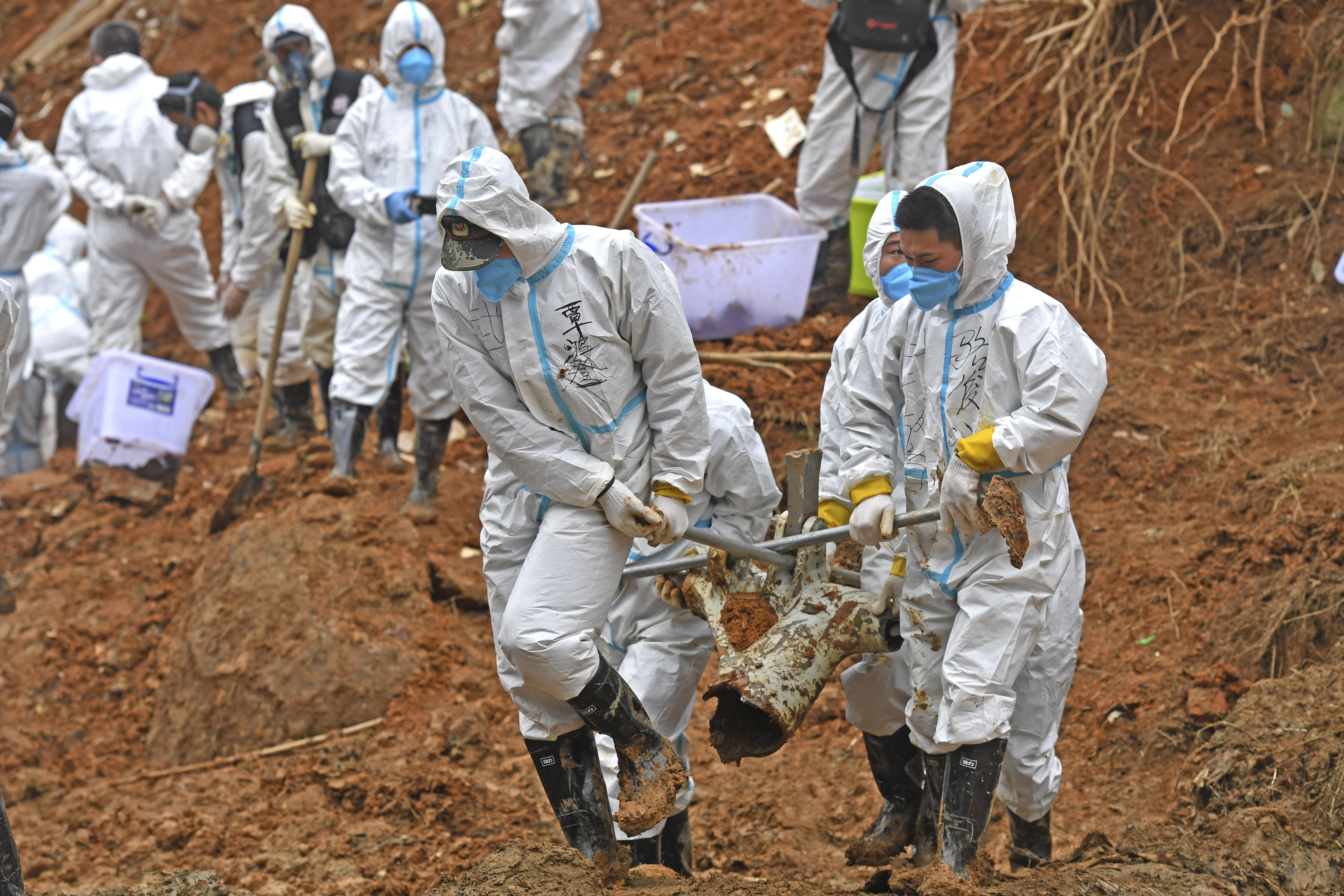 In this photo released by Xinhua News Agency, rescuers carry a piece of plane wreckage at the site of Monday's plane crash in Tengxian County, southern China's Guangxi Zhuang Autonomous Region, Friday.