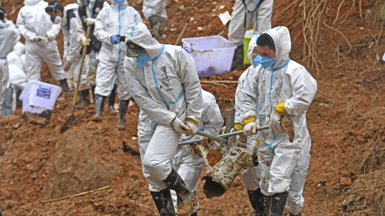 In this photo released by Xinhua News Agency, rescuers carry a piece of plane wreckage at the site of Monday's plane crash in Tengxian County, southern China's Guangxi Zhuang Autonomous Region, Friday.
