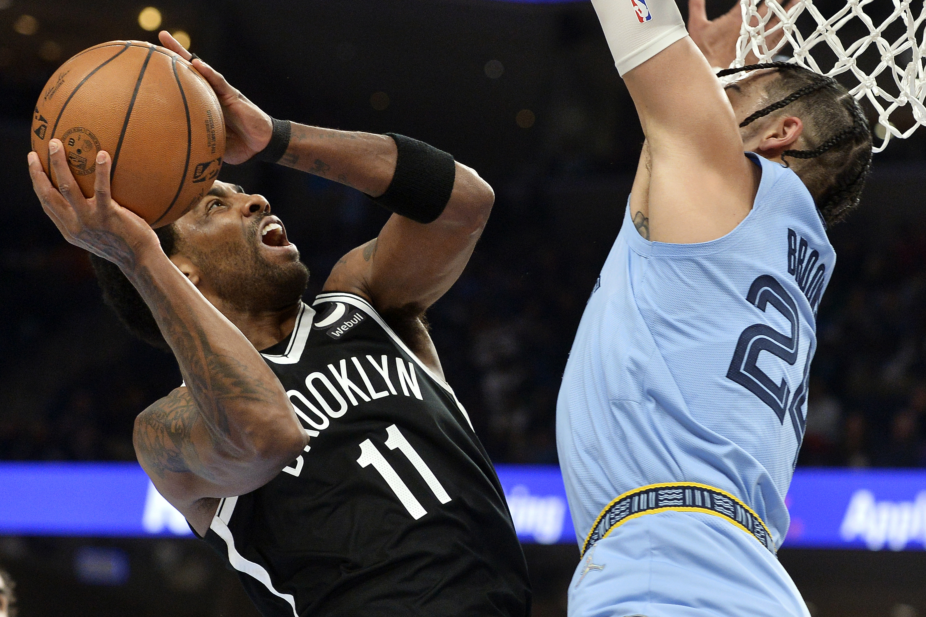 Brooklyn Nets guard Kyrie Irving (11) shoots against Memphis Grizzlies forward Dillon Brooks (24) during the first half of an NBA basketball game Wednesday, March 23, 2022, in Memphis, Tenn.