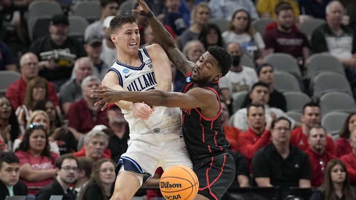 Villanova guard Collin Gillespie passes around Houston guard Jamal Shead during the first half of a college basketball game in the Elite Eight round of the NCAA tournament on Saturday, March 26, 2022, in San Antonio.