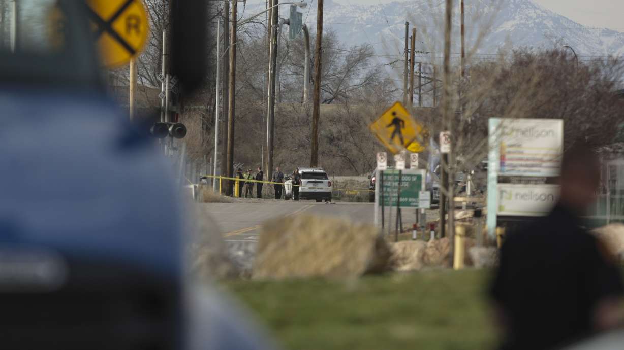 Salt Lake City police work at the scene after shots were fired following a carjacking on Orange Street near 200 South in Salt Lake City on Saturday.