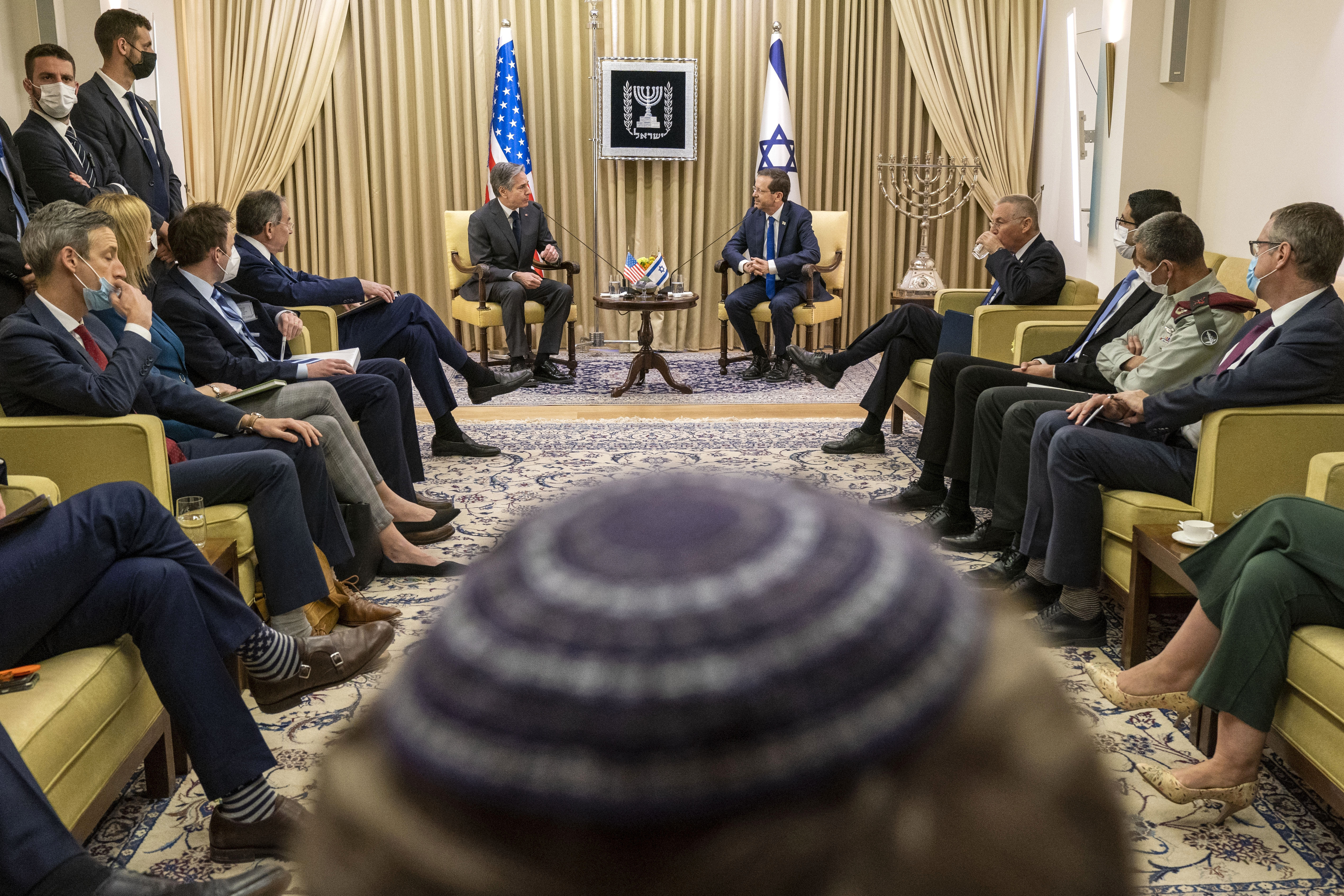 A photographer in the foreground wears a kippah, as U.S. Secretary of State Antony Blinken, back left, meets with Israel's President Isaac Herzog at the Presidency, Sunday in Jerusalem.
