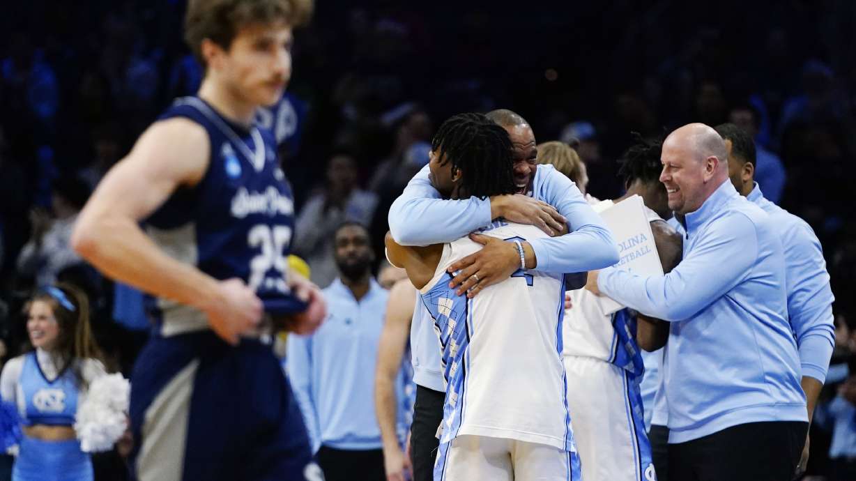 North Carolina's Hubert Davis and Caleb Love celebrate after a college basketball game against St. Peter's in the Elite 8 round of the NCAA tournament, Sunday, March 27, 2022, in Philadelphia.