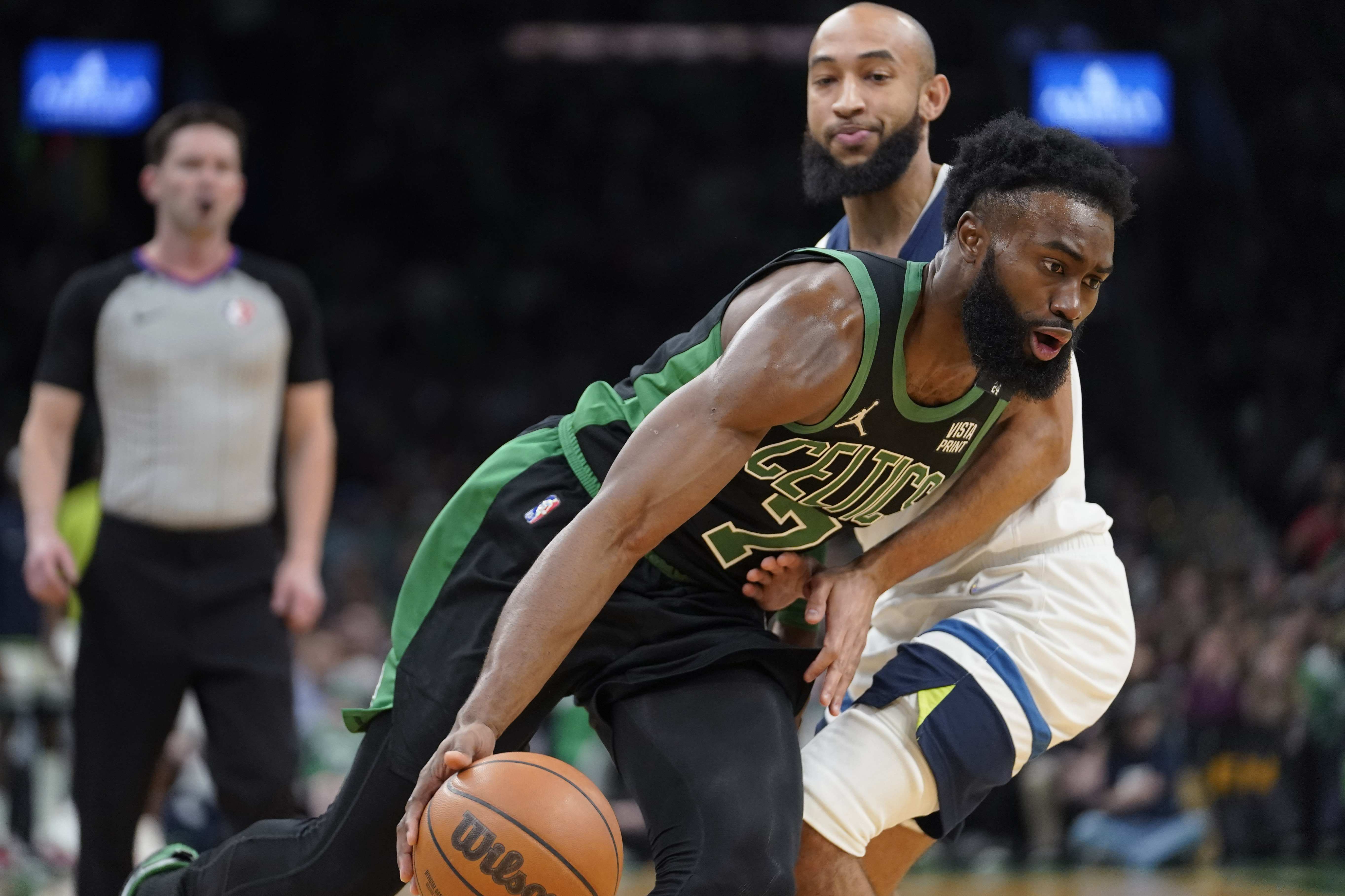 Boston Celtics guard Jaylen Brown (7) drives toward the basket past Minnesota Timberwolves guard Jordan McLaughlin (6) in the first half of an NBA basketball game, Sunday, March 27, 2022, in Boston. 