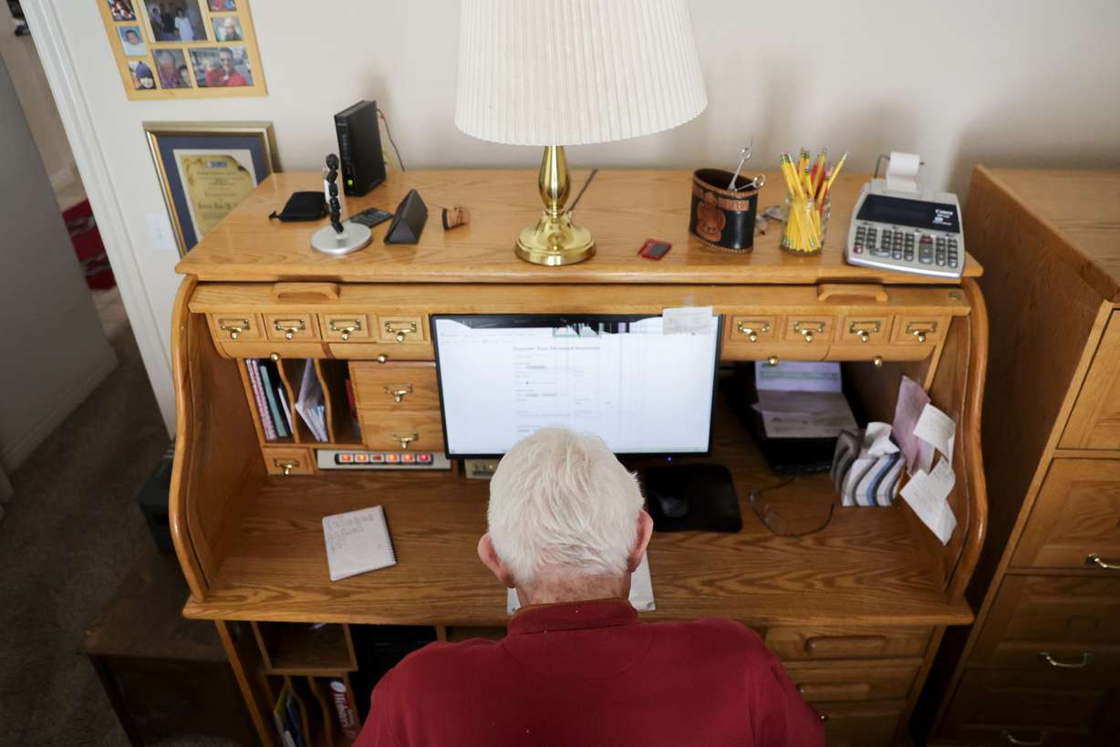 Dale Adams, 88, whose retirement hobby is downloading obituaries from newspaper archives from the 19th century and updating the information on FamilySearch, works at his house in Park City on March 14.