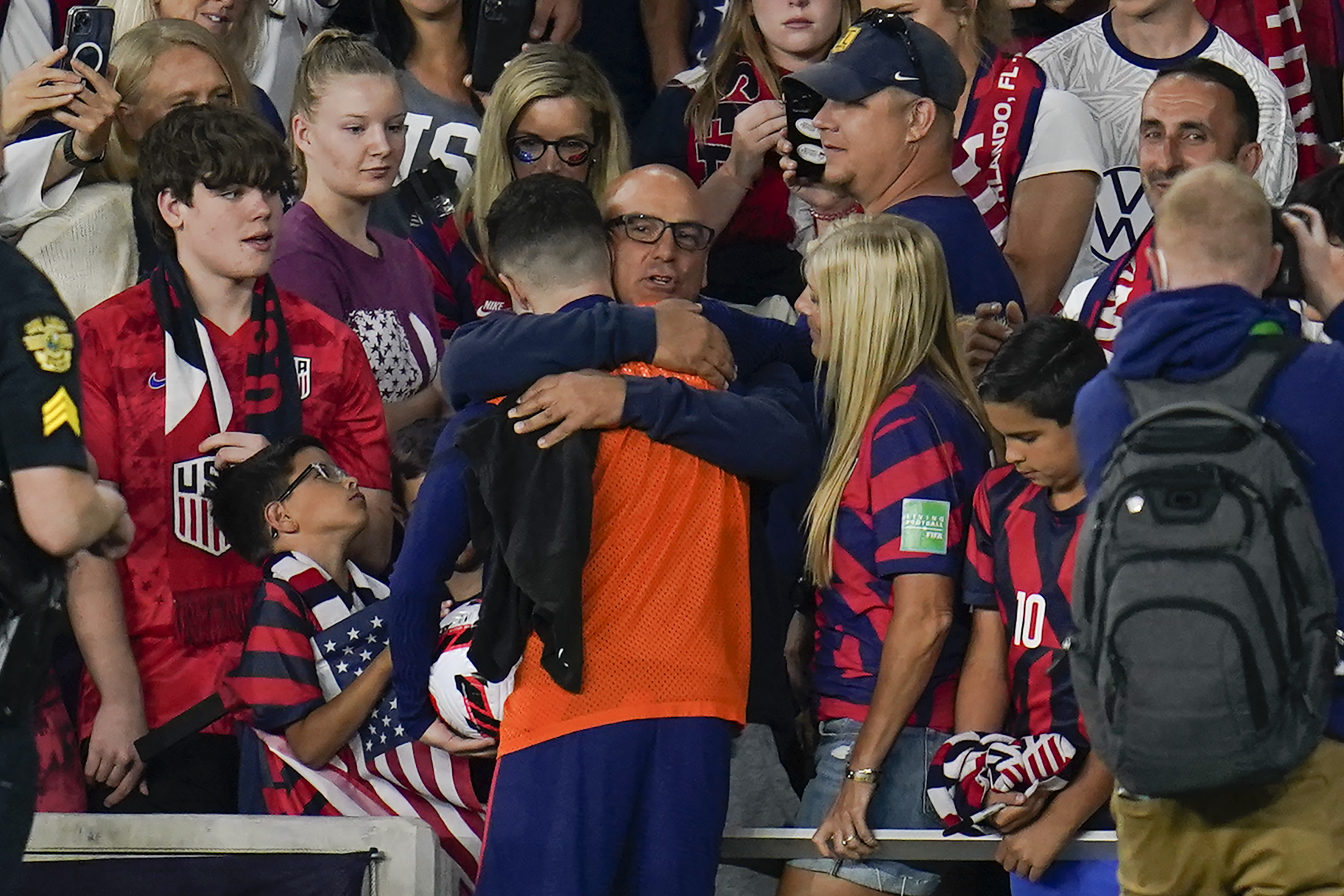 United States' Christian Pulisic, in orange top, is hugged by his father Mark Pulisic, center, after Christian Pulisic scored three goals in a FIFA World Cup qualifying soccer match against Panama, Sunday, March 27, 2022, in Orlando, Fla. The U.S. won 5-1. 